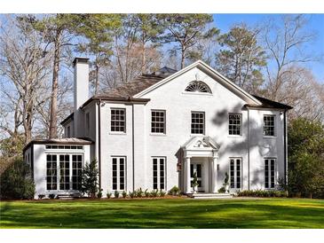 Elegant white brick home with symmetrical windows and a well-manicured lawn offers classic curb appeal at 3051 Habersham Nw Rd, Atlanta, GA 30305