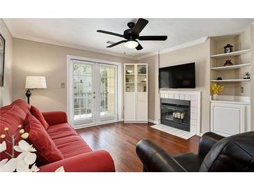 Bright living room featuring a ceiling fan, a fireplace, hardwood floors, and French doors to the outside at 3655 Habersham Ne Rd # 226-A, Atlanta, GA 30305