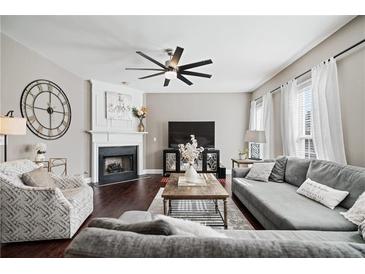 Inviting living room with a fireplace, modern ceiling fan, and comfortable seating arrangement at 2471 Bridlewood Se Dr # 8, Atlanta, GA 30339