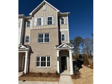 Charming townhome featuring brick facade, gray siding, and well-manicured landscaping at 1915 Cassia Aly, Kennesaw, GA 30144