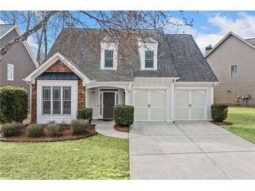 Charming traditional home featuring a manicured lawn, two-car garage, and brick accents at 1168 Christiana Xing, Lawrenceville, GA 30043