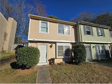 Inviting townhouse featuring a charming facade, well-maintained lawn, and lush shrubbery at 1711 Nappa Valley Se Ct, Smyrna, GA 30080