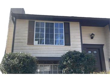 Charming townhome featuring a large window with dark trim, shutters, and a well-maintained facade at 4233 Village Square Ln, Stone Mountain, GA 30083