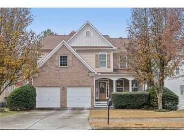 Two-story brick and siding home featuring an attached two-car garage and a covered front porch at 1312 Preserve Park Dr, Loganville, GA 30052