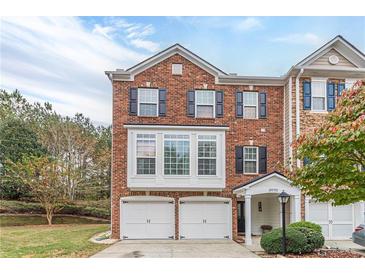 Charming brick townhome featuring a two-car garage and well-maintained landscaping at 3970 Church View Ln, Suwanee, GA 30024