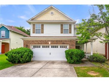 Charming two-story home with brick accents, a white garage door, and well-maintained landscaping at 2524 Oakleaf Rdg, Lithonia, GA 30058