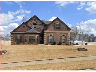 Charming brick home featuring a manicured front lawn and a two-car garage at 3492 Maple Hill Rd, Lithonia, GA 30038