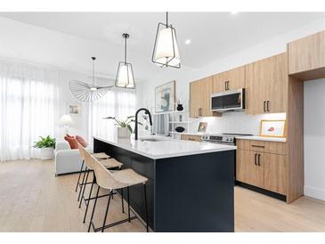 Modern kitchen features an island with seating and contemporary pendant lighting at 567 Ponce De Leon Ne Ave # 614, Atlanta, GA 30308