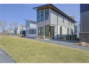 Modern two-story home featuring large windows, sleek design, and well-manicured lawn at 115 Arcadia Ave, Fayetteville, GA 30214