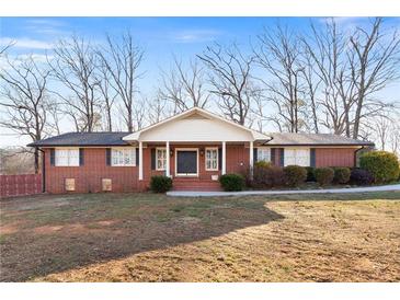 Charming brick home with a covered porch and mature trees in the front yard at 19 Roving Rd, Cartersville, GA 30121