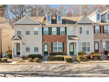 Charming townhome with a mix of brick and siding, complemented by well-maintained landscaping and ample parking spaces at 1331 Penhurst Dr, Lawrenceville, GA 30043