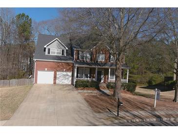 Charming two-story brick home with a welcoming front porch and a spacious two-car garage at 2124 Mitford Ct, Dacula, GA 30019