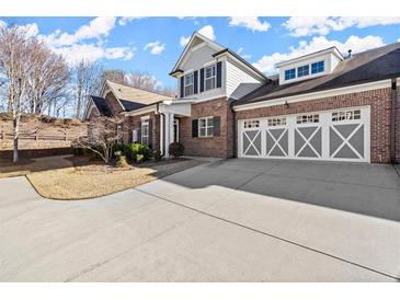 Charming brick home featuring a three car garage and manicured landscaping at 2752 Middlecreek Way, Cumming, GA 30041