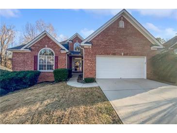 Charming brick home featuring a two-car garage, landscaped front yard, and welcoming entrance at 4540 Flat Willow Pl, Douglasville, GA 30135