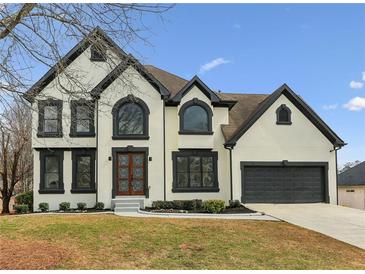 Charming two-story home featuring a mix of white and black trim, a gray garage door, and a well-manicured lawn at 4340 Boxwood Trl, Ellenwood, GA 30294