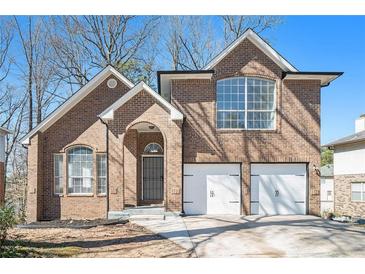 Charming brick two-story home with attached two car garage and arched front entry at 613 Woodstone Rd, Lithonia, GA 30058
