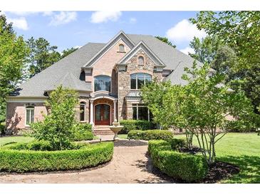 Beautiful brick and stone home showcasing manicured landscaping and a welcoming entrance at 8480 St Marlo Fairway, Duluth, GA 30097