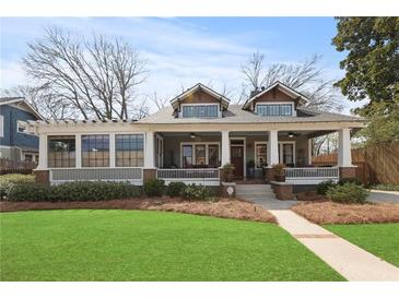 Charming two-story home with a covered porch, well-manicured lawn, and inviting curb appeal at 1518 Cambridge Ave, Atlanta, GA 30337