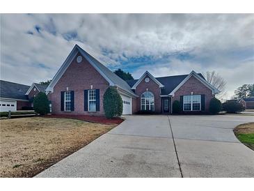 Charming brick home with a well-manicured lawn and a long driveway at 930 Rafington Dr, Lawrenceville, GA 30046