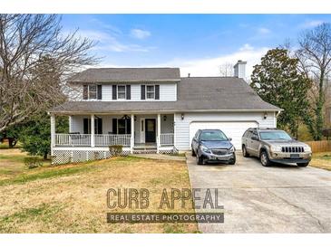 Charming two-story home with a welcoming front porch and attached two-car garage at 1710 Meadowchase Ct, Snellville, GA 30078