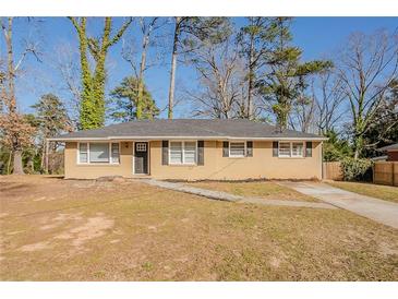 Charming single-story home featuring a welcoming front yard and long driveway at 1932 Rosewood Rd, Decatur, GA 30032