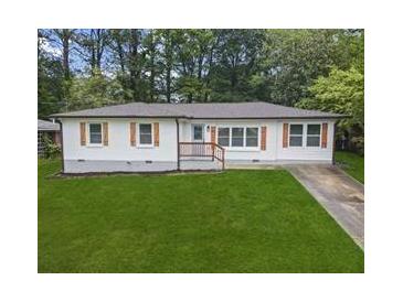 Charming home featuring a well-maintained lawn, white siding, wood shutters, and a cozy front porch at 2478 Graywall St, Atlanta, GA 30344