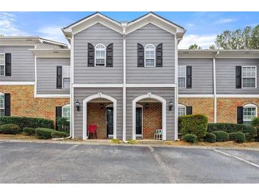 Charming townhome featuring brick accents, neutral siding, and decorative shutters on the upper windows at 204 Summer Pl, Norcross, GA 30071