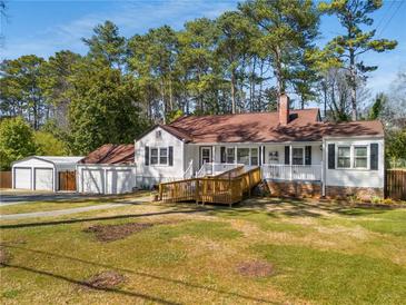 Charming home with a welcoming porch, landscaped front yard, and a convenient detached two-car garage at 4100 Brown Rd, Tucker, GA 30084