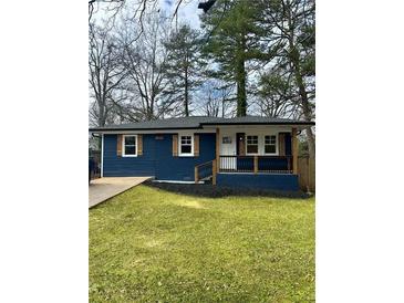 Charming blue house featuring a well-manicured lawn and inviting front porch at 1889 Cannon St, Decatur, GA 30032