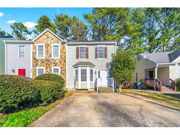 Charming two-story townhome featuring stone accents, bay window, and well-maintained landscaping at 858 Heritage Valley Rd, Norcross, GA 30093