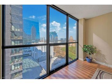 Bright living room with large windows providing panoramic city views and hardwood floors at 1280 W Peachtree Nw St # 2302, Atlanta, GA 30309