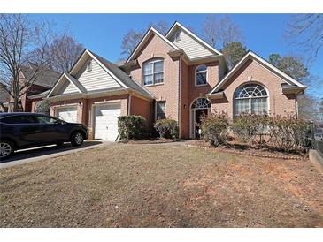 Charming brick home with a well-manicured lawn and a two-car garage at 4584 Madison Place Ln, Atlanta, GA 30360