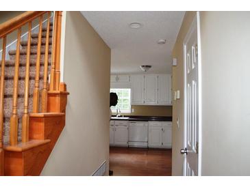 Welcoming entryway with hardwood stairs, neutral paint, and a glimpse into the bright kitchen at 100 Shoreline Dr, Fayetteville, GA 30215