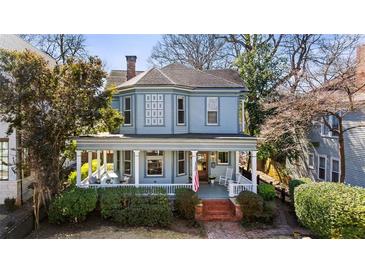 Charming blue two-story home with a spacious front porch, perfect for relaxing outdoors at 513 Saint Charles Ne Ave, Atlanta, GA 30308