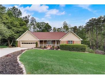 Charming single Gathering home with a well-manicured lawn, 2-car garage, and inviting front porch at 1165 Saint Ives Ct, Suwanee, GA 30024