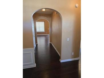 Inviting hallway features dark hardwood floors and elegant archway leading into the home at 3121 Baywood Ct, Conyers, GA 30013