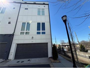 Modern townhome with gray garage door and light colored siding, complemented by large windows at 827 Winslow Nw Way, Atlanta, GA 30318