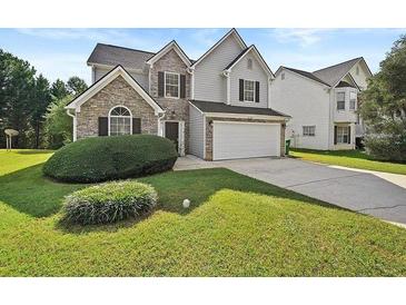 Charming two-story home featuring stone and gray siding, a two car garage, and a well maintained lawn at 2133 Creekview Trl, Decatur, GA 30035