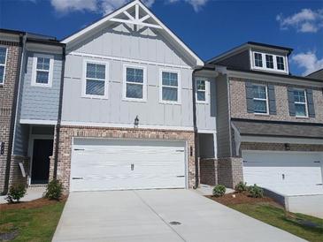 Charming townhome showcasing a brick-accented facade, attached garage, and meticulously maintained landscaping at 340 Sinclair Ct # 75, Mcdonough, GA 30253