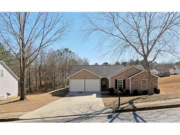 Charming single Gathering home featuring a two-car garage and well-maintained front yard with mature trees at 3577 N Winds N Trl, Douglasville, GA 30135