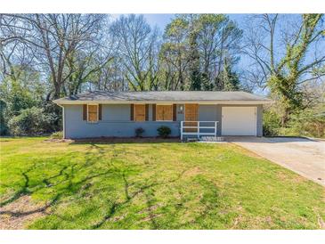 Ranch style home with a gray painted brick exterior and a well maintained front lawn at 3761 Turner Heights Dr, Decatur, GA 30032