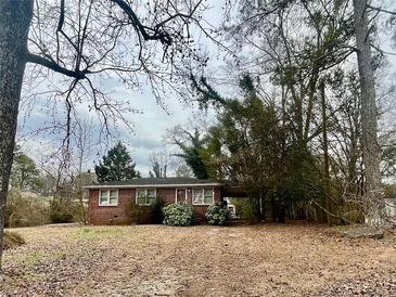 Charming red brick home with mature trees and landscaped front yard at 2956 Cruse Rd, Lawrenceville, GA 30044