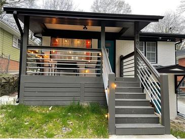 Inviting covered front porch with gray decking, modern railings, and a cozy seating area; perfect for relaxing outdoors at 280 Spellman Nw St, Atlanta, GA 30314