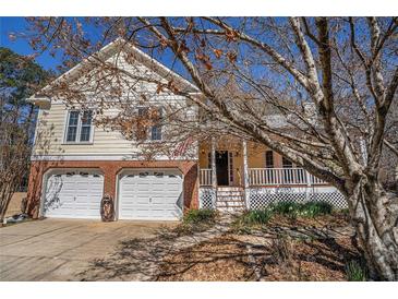 Charming home with two-car garage and inviting front porch, perfect for relaxing outdoors at 3423 Conley Downs Dr, Powder Springs, GA 30127