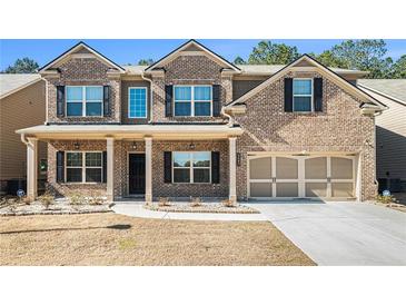 Charming brick two-story home with a welcoming front porch and a well-manicured lawn at 3405 Linstead Ct, Loganville, GA 30052