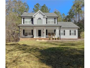 Charming two-story home with black shutters, covered porch, and well-maintained lawn at 815 Lake Stone Lea Dr, Oxford, GA 30054