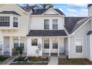 Charming townhome with white siding, covered front porch, and well-manicured lawn at 5915 Trent Walk Dr, Lithonia, GA 30038