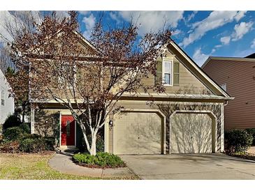 Charming two-story home with a two-car garage, landscaped yard, and inviting red front door at 2829 Priestcliff Se Dr, Smyrna, GA 30080