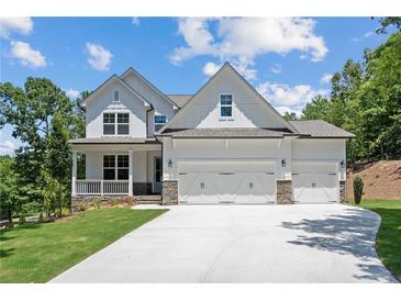 Beautiful two-story home featuring a three-car garage, front porch, and manicured lawn at 385 Riverwood Pass, Dallas, GA 30157