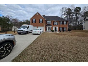 Charming two-story brick home with a two-car garage and well-maintained front yard at 9620 Carolina Dr, Jonesboro, GA 30238